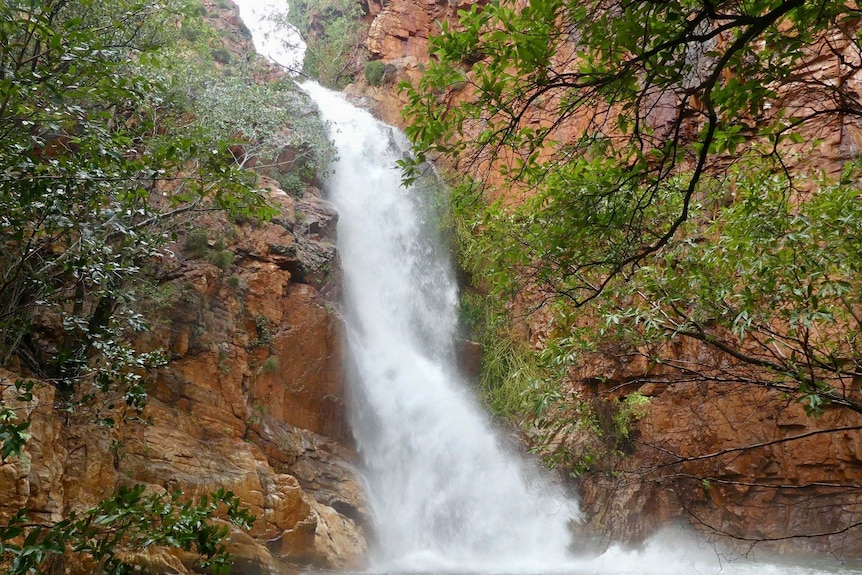 Close up of waterfall splashing over red rocks