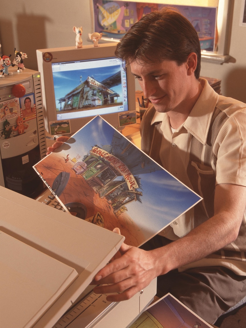 Rove McManus handling animation cels at a computer