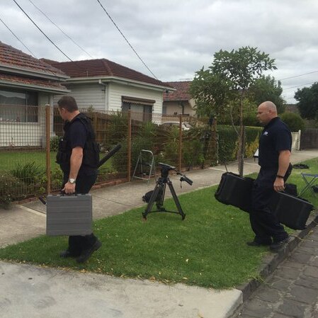 AFP officers enter a home in Melbourne's west