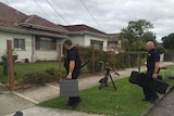 AFP officers enter a home in Melbourne's west