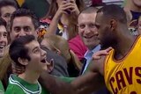 LeBron James surprises fan Aaron Miller during an NBA game.