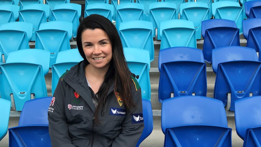 Emma Doherty, Player Development Manager at Cricket Tasmania, sitting in the spectator seats at Bellerive Oval.
