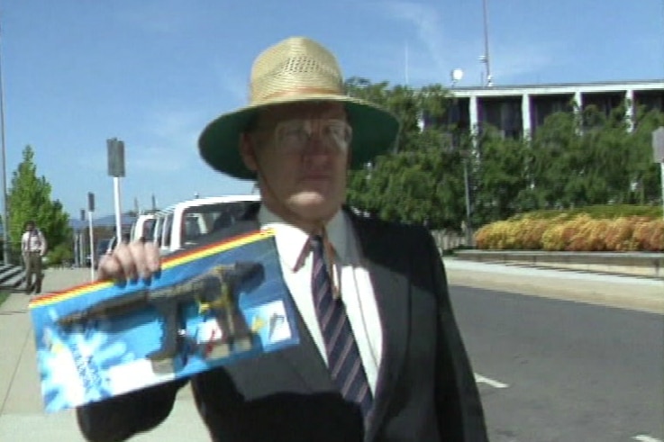 David Eastman holds up a toy gun in its packaging.