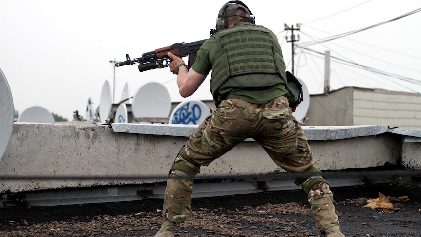 Pro-Russia militants shoot from a roof of a residential building in the Ukrainian city of Luhansk.