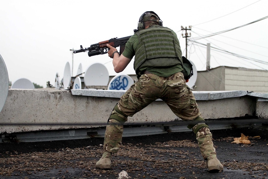 Pro-Russia militants shoot from a roof of a residential building in the Ukrainian city of Luhansk.