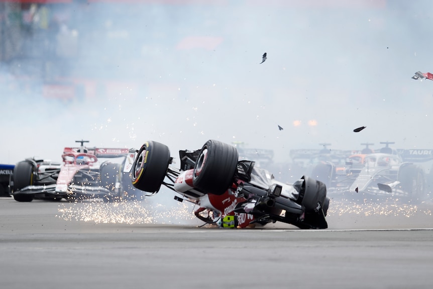 Zhou Guanyu's Formula 1 car is seen upside down with smoke and sparks around it