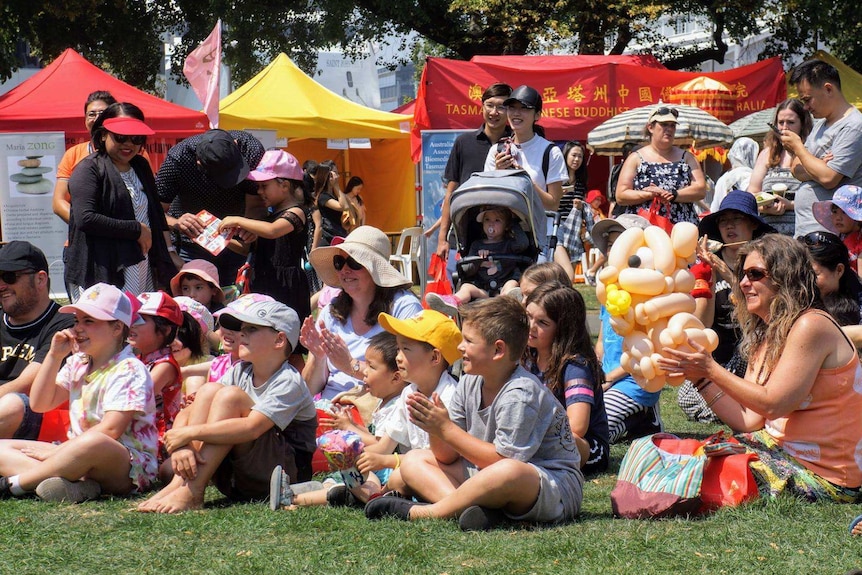 A group of people sitting on the ground.