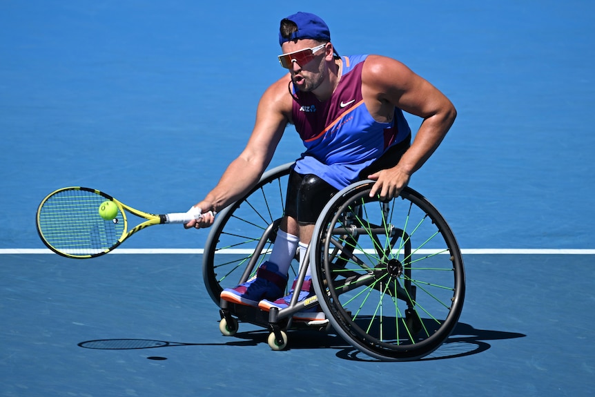 Un joueur de tennis masculin australien frappe un coup droit dans un match en simple en fauteuil roulant quadruple.