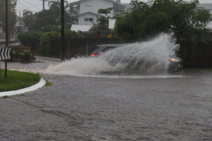 A car drives through floodwater.