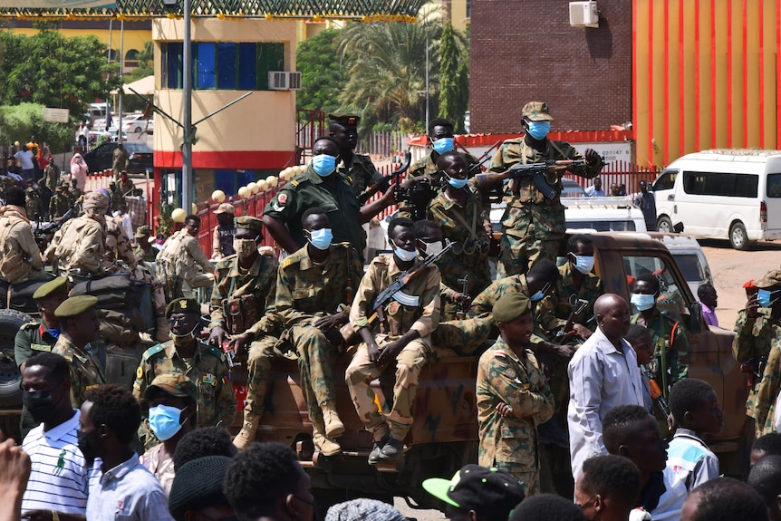 Sudanese soldiers keep watch over a military hospital and government offices during an anti-coup protest.