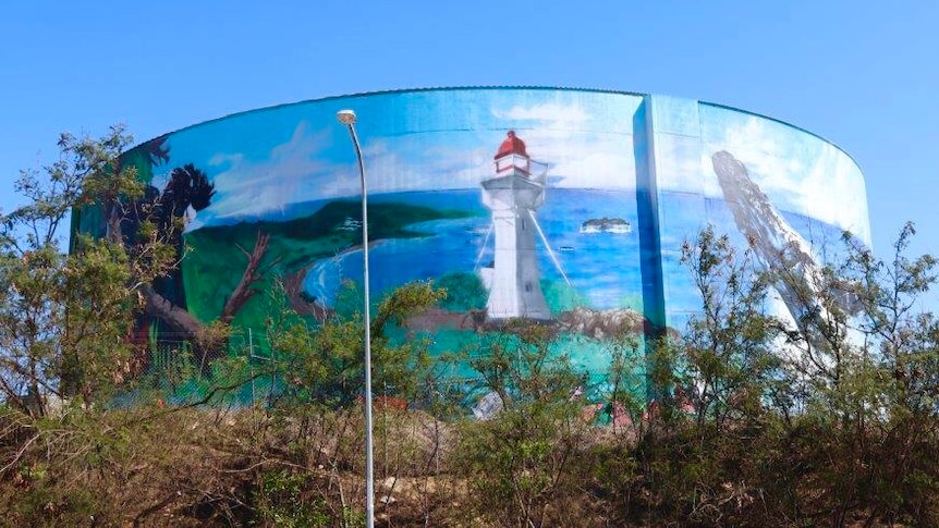 A water tower with a lighthouse painted on it