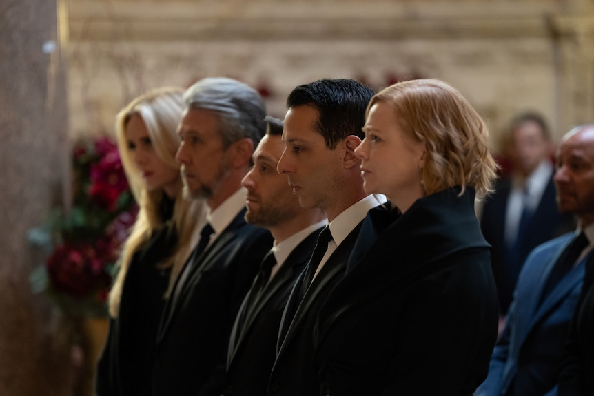 The Roy siblings stand shoulder to shoulder at a funeral.