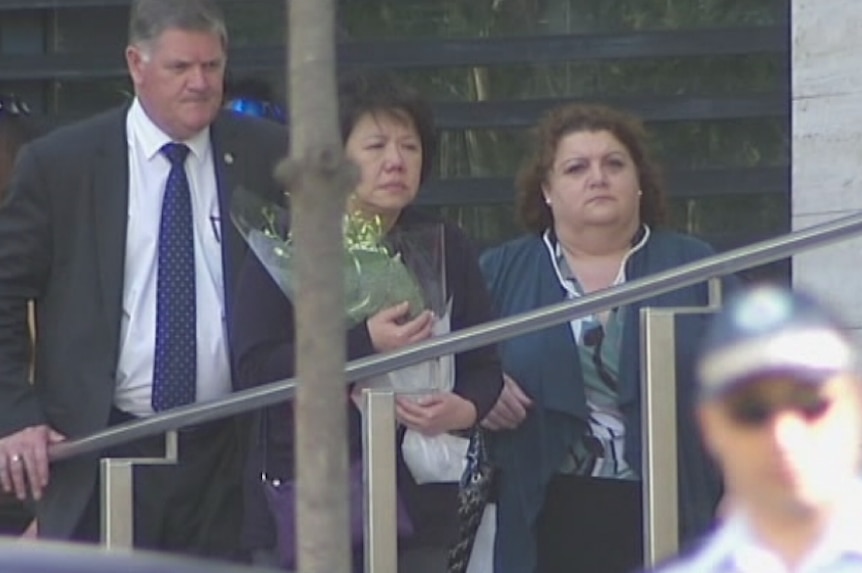 Members of Curtis Cheng's family lay flowers outside NSW Police headquarters