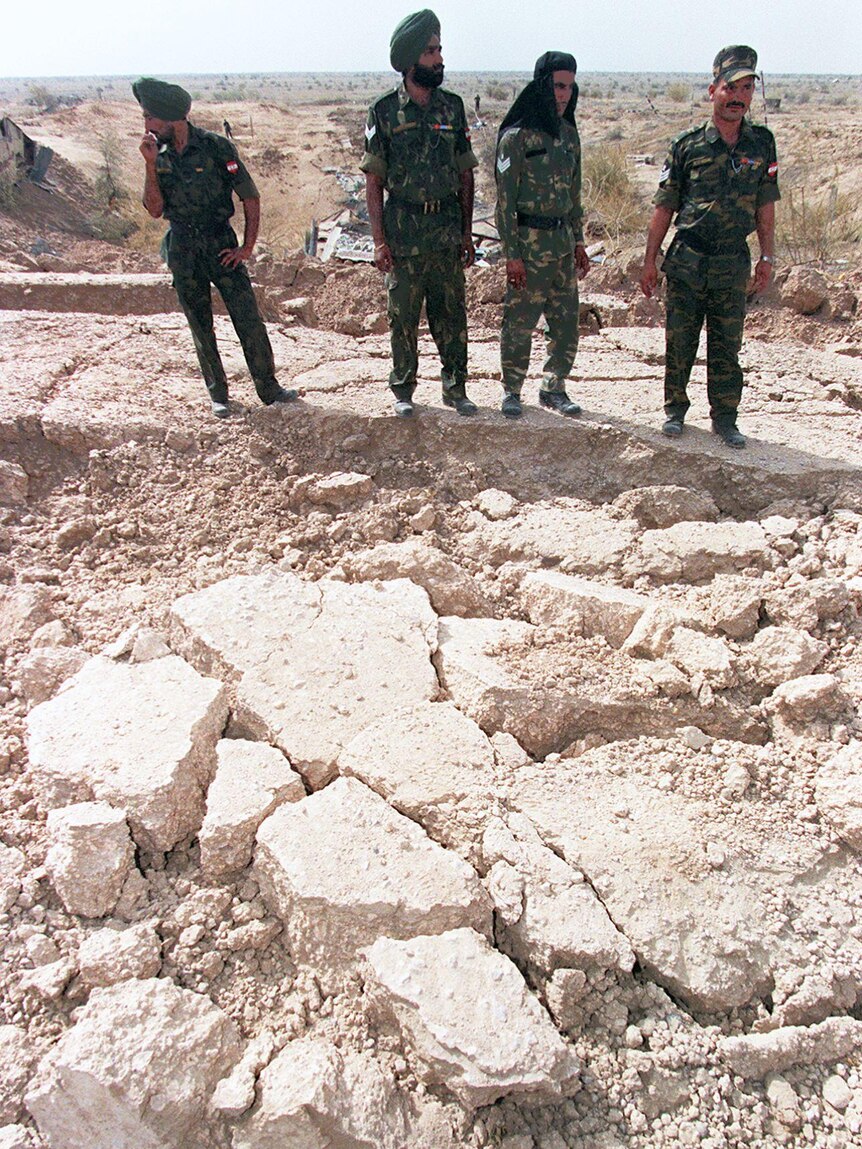 Indian soldiers stand guard on shattered ground on the edge of the crater at the Shakti-1 site of the Pokhran nuclear test site, 1998