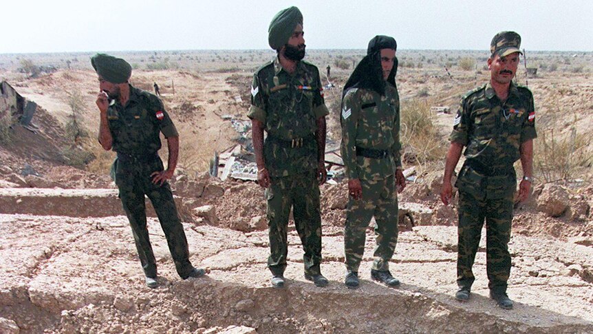 Indian soldiers stand guard on shattered ground on the edge of the crater at the Shakti-1 site of the Pokhran nuclear test site, 1998