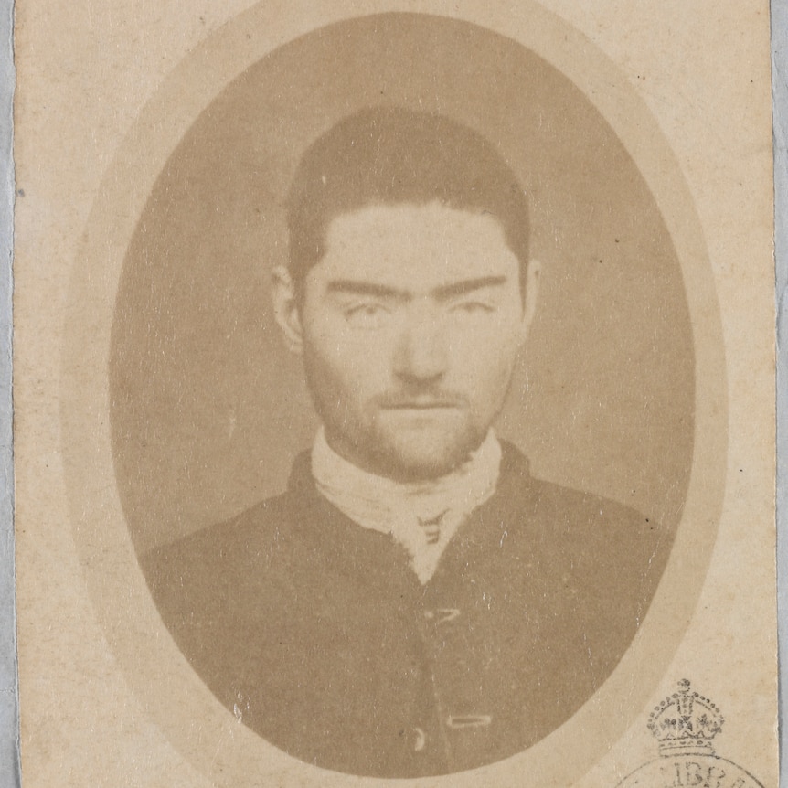 An oval-shaped black and white image of Ned Kelly 