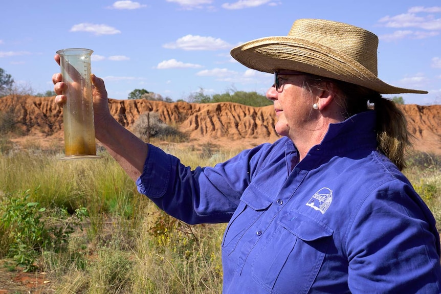 Noonbah Station owner Karen Emmott and the rain gauge they've checked daily for a century