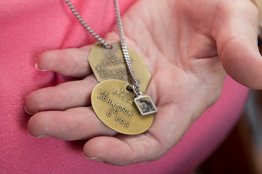 Amanda Johnston holds her son Ashley Johnston's military dog tags in her hand.