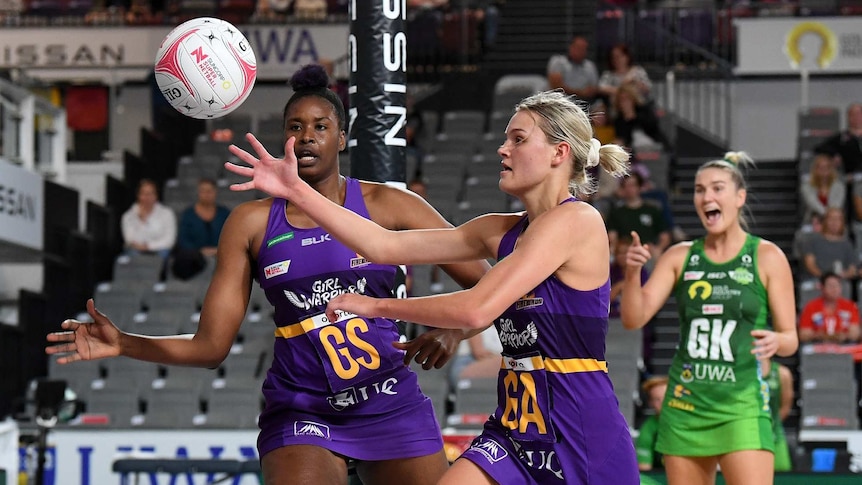 Tippha Dwan (centre) of the Queensland Firebirds reaches out for the ball
