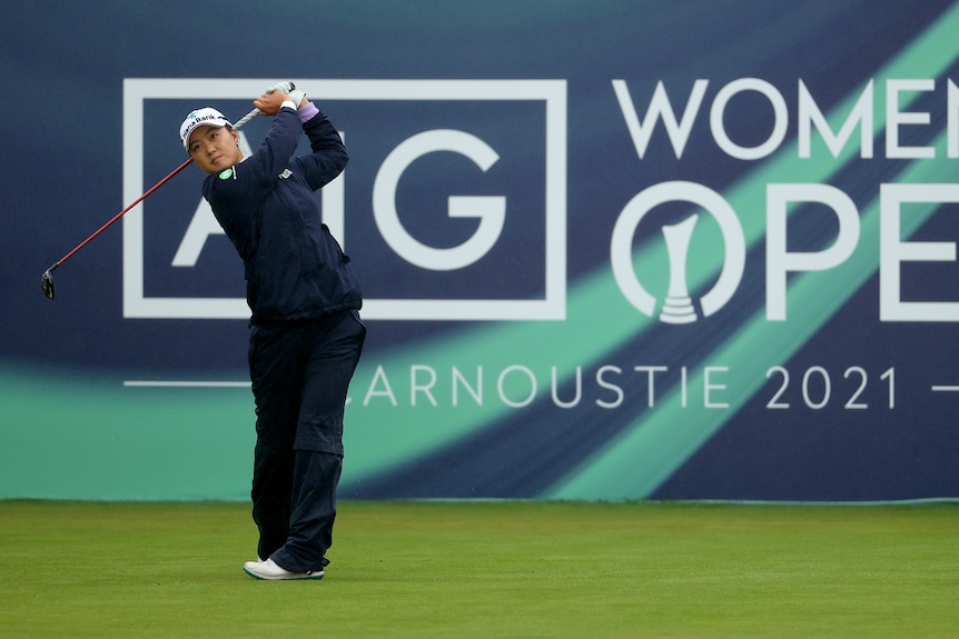 Minjee Lee hits a tee shot in front of a sign that reads "WOMEN'S OPEN - Carnoustie 2021"