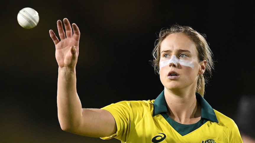 Ellyse Perry of Australia raises her hand to catch a cricket ball.