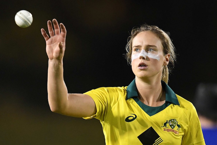 Ellyse Perry of Australia raises her hand to catch a cricket ball.