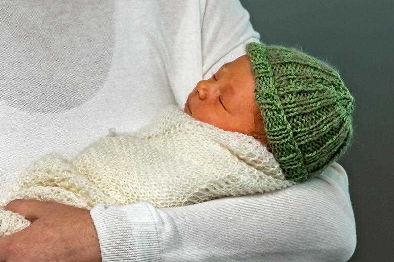 Neve Te Aroha Ardern Gayford wrapped in a cream knitted blanket and wearing a green knitted hat