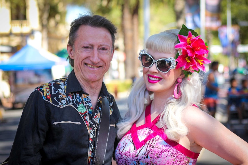 Man in a cowboy shirt and his wife in pink with beautiful flower in her hair