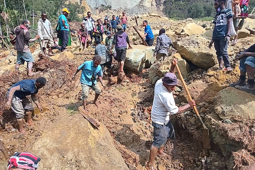 A photo of people digging at the site of a landslide.