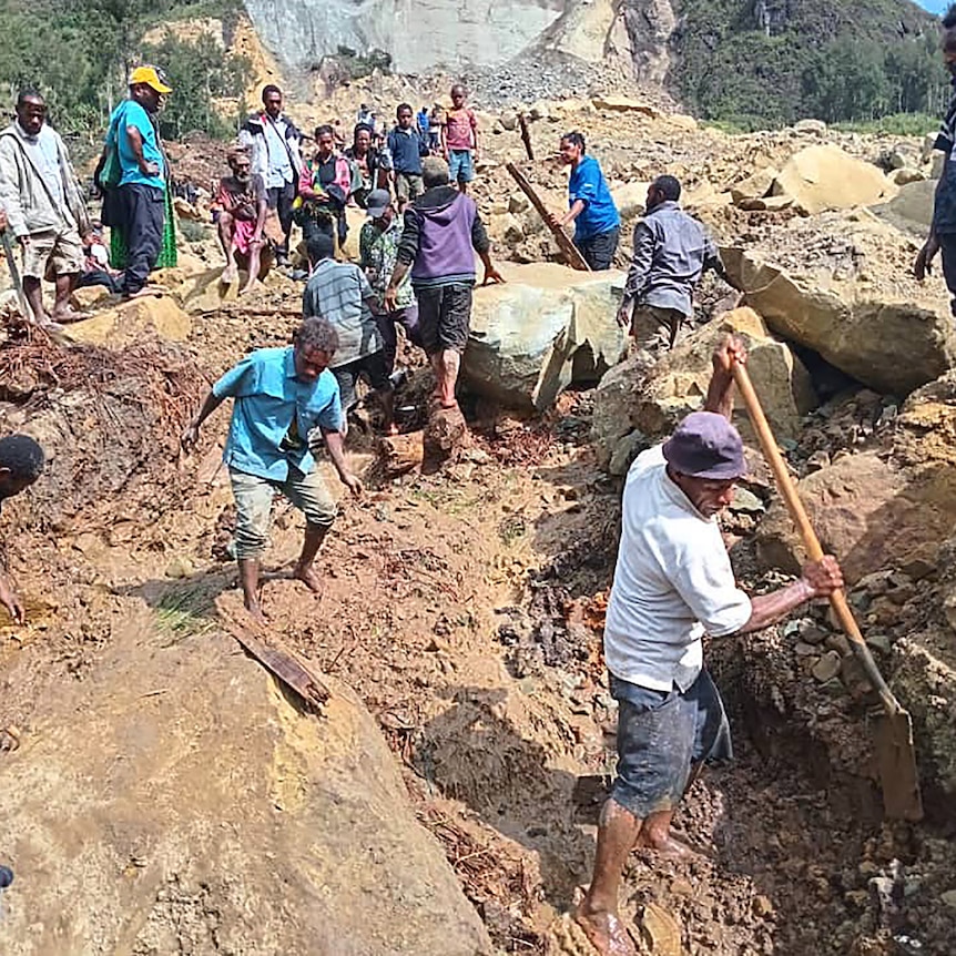 A photo of people digging at the site of a landslide.