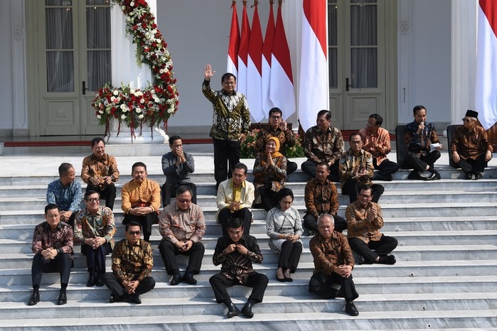 Indonesian ministers sitting on the country's presidential palace stairs.
