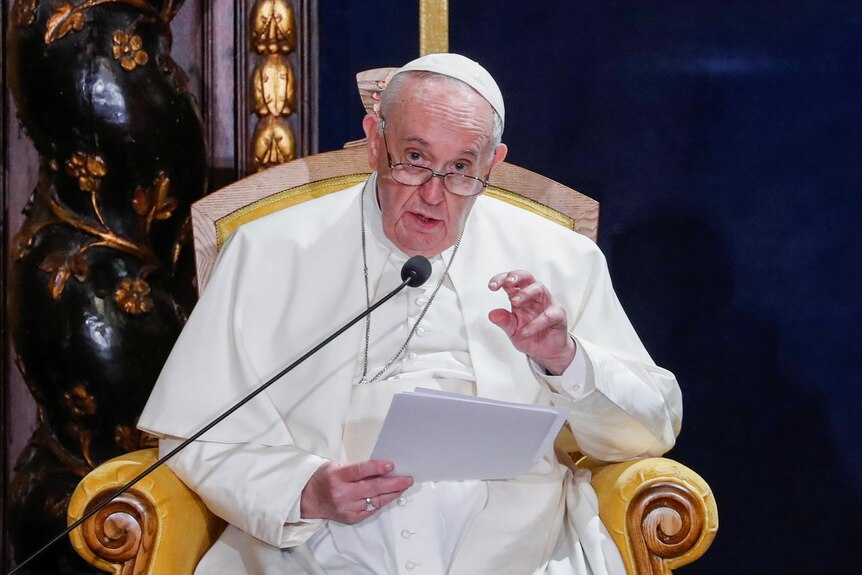 Pope Francis speaks while seated.