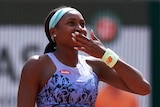 American tennis player Coco Gauff smiles as she puts here hand over her mouth in delight after a match at the French Open. 