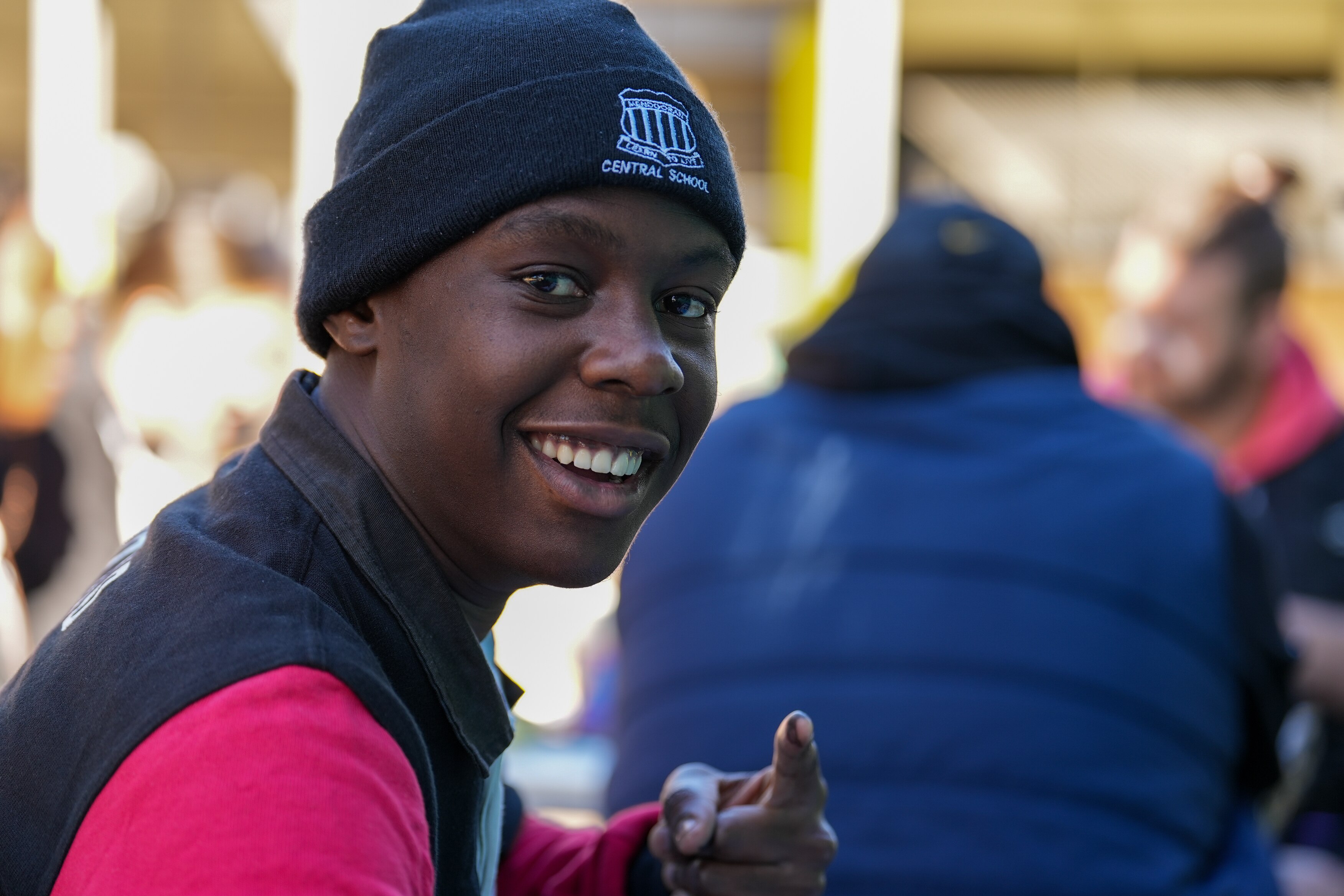 A student smiles and points.