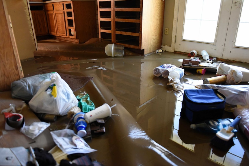 Debris and water cover Emma Smith's kitchen floor after days of flooding in Missouri