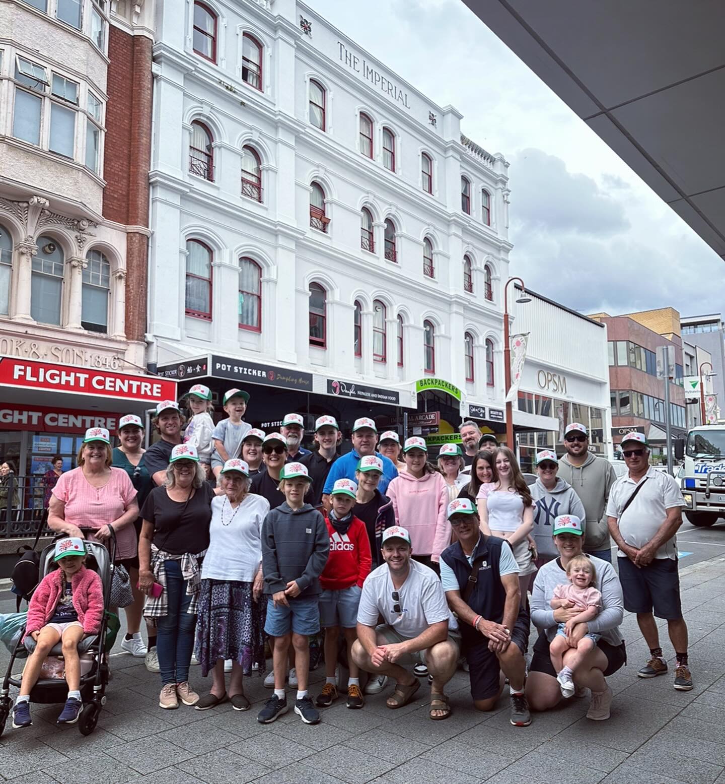 Large family group stand in front of hotel