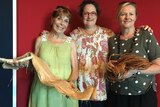 Lesley Kane, Fiona Vuibeqa and Wanda Bennett stand holding traditional Fijian materials.