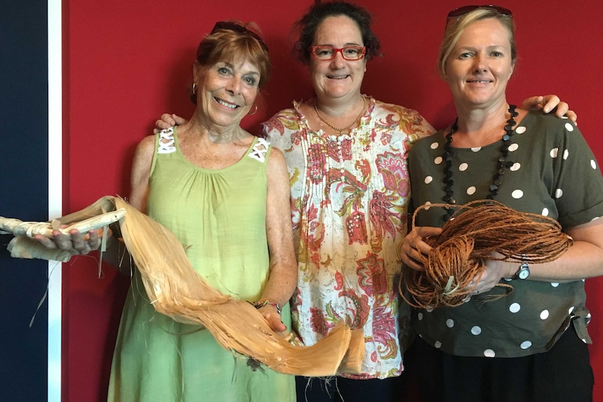 Lesley Kane, Fiona Vuibeqa and Wanda Bennett stand holding traditional Fijian materials.