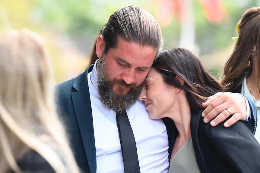 Rhys and Danielle Carrol hug outside of court.