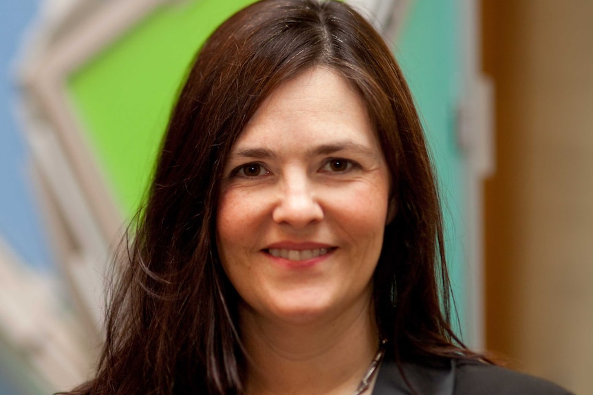 Nancy Baxter, a woman with dark brown hair, smiles at the camera.