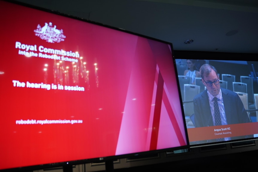 Robodebt royal commission Counsel Assisting Angus Scott KC speaking on the right, in session sign on the left