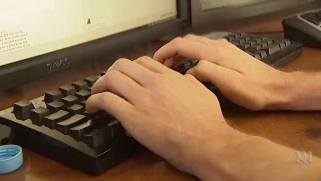 Hands rest on a computer keyboard