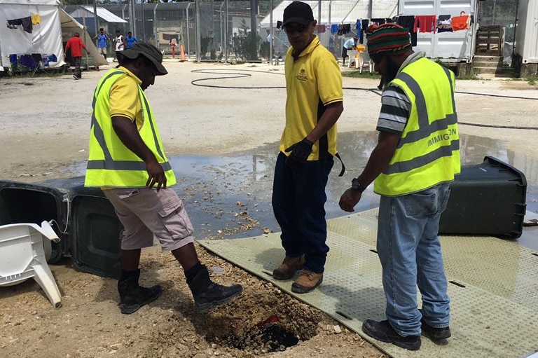 Immigration officials in the Manus Island detention centre burying drinking water wells.