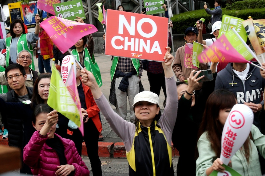 A woman holds up a sign that reads "no China" amid supporters of Tsai Ing-wen.