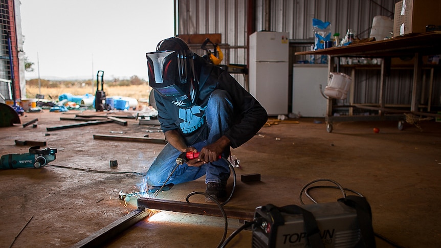 Metal worker in the community workshop in Warburton welding.