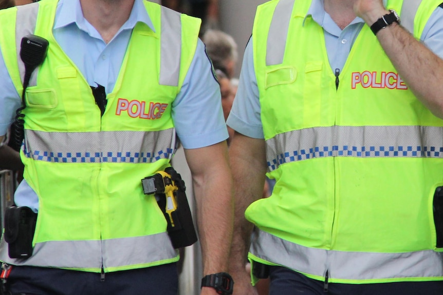 Queensland Police walk through the Queen Street Mall.