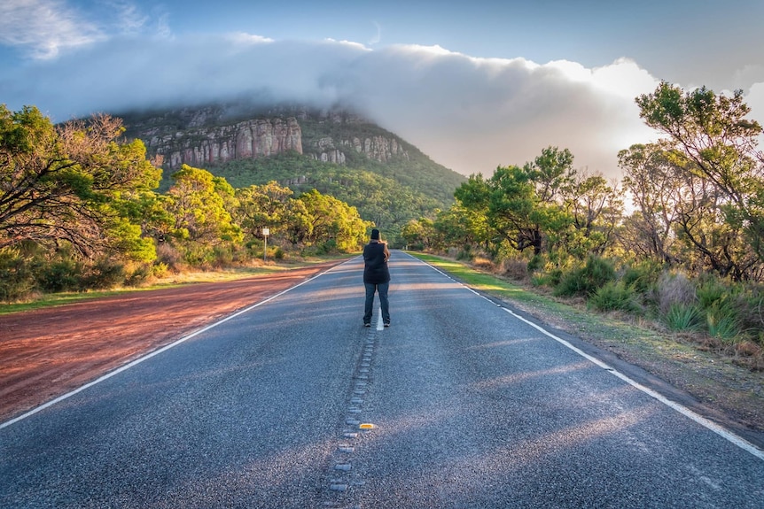 A person stands in the middle of the road in Dunkeld