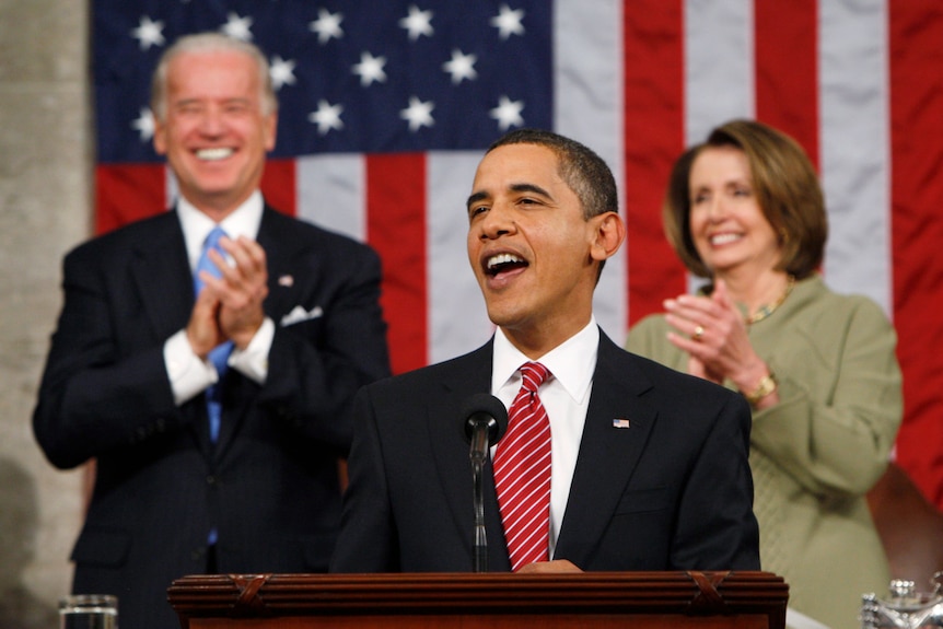 Barack Obama speaking at a podium with the US flag behind him.