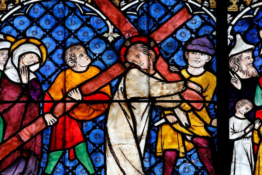 A stained glass window showing Jesus carrying the Cross