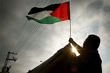 A Palestinian security man raises a flag at a Gaza security post (Reuters: Suhaib Salem)